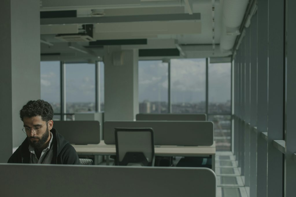 Man working in a modern open-plan office with a city view.