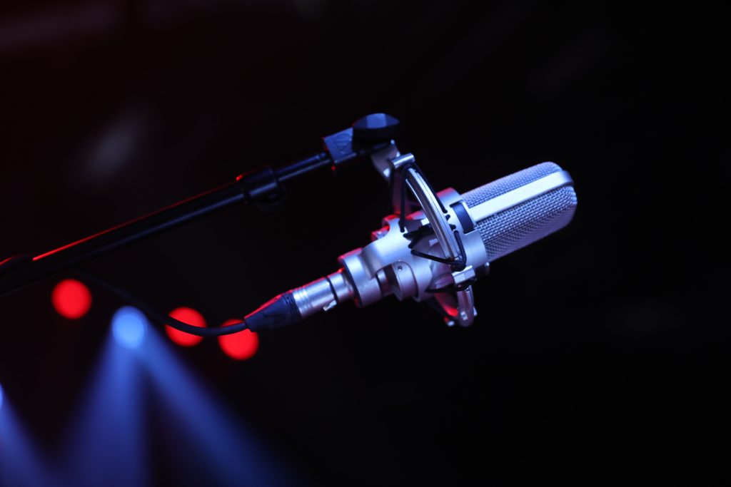 Close-up of a professional microphone on a stage with vibrant lighting in Paris, France.